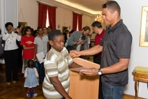 Daniel Narcisse remet son diplôme à un enfant sélectionné.