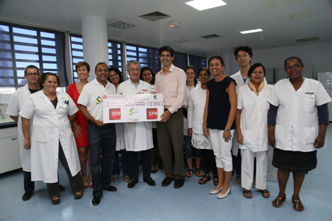 Ibrahim Ingar (1000 Sourires), Yves Gauvin et Caroline Gaudel (SFR) ont remis un chèque de 5000 Euros au docteur François Cartault en présence des membres de  l'équipe de recherche du service de Génétique du CHU de Bellepierre.