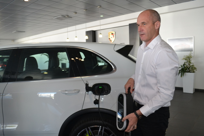 Bertrand Chartier, le directeur du Centre Porsche Réunion, montre le chargeur du Cayenne hybride
