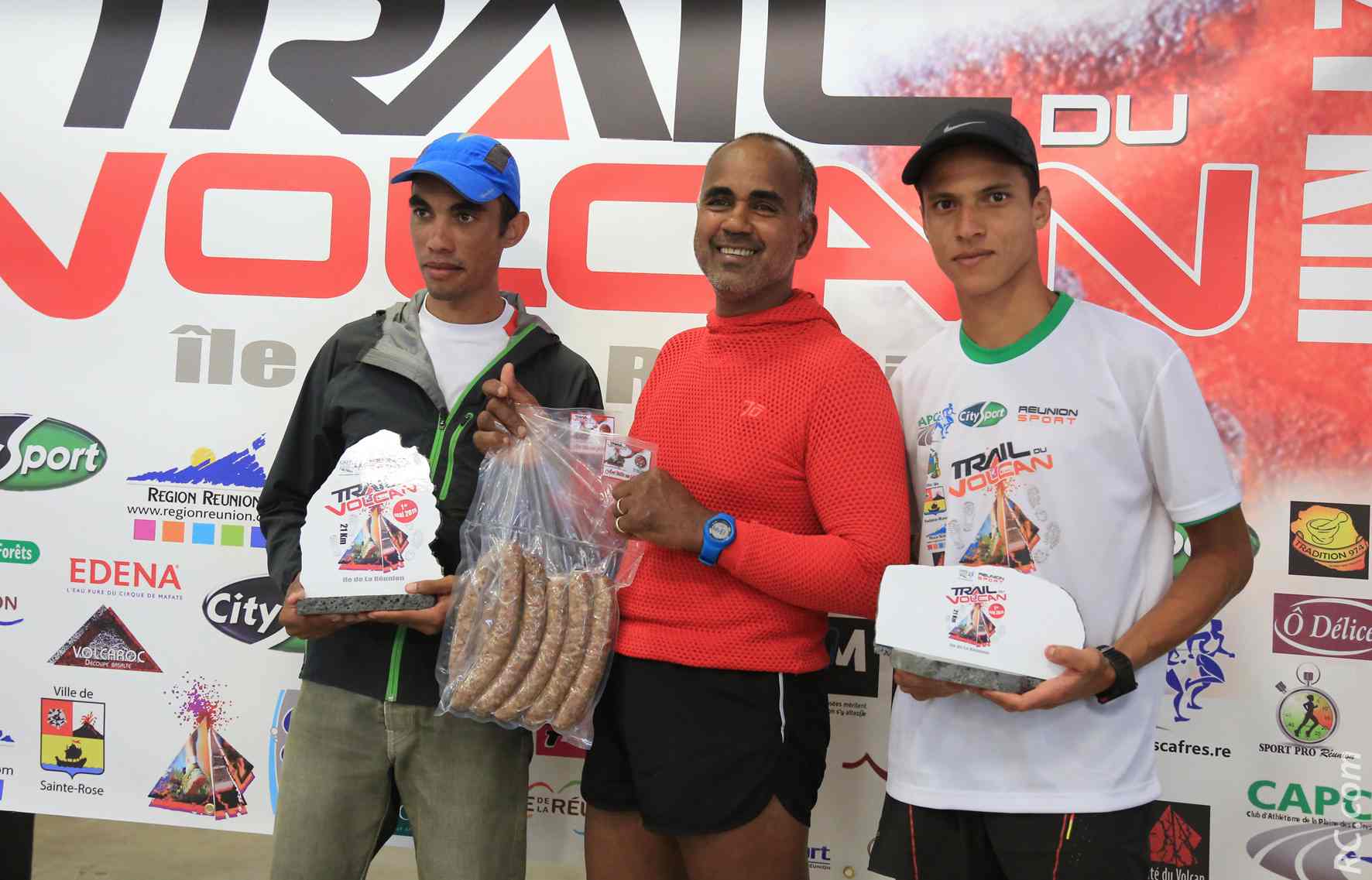 Géraldo Trulès et Nicolas Julien reçoivent les saucisses d'or de Jean-Pierre Vee (au centre), un ancien marathonien des Jeux des Iles de l'Océan Indien en… 1979 !