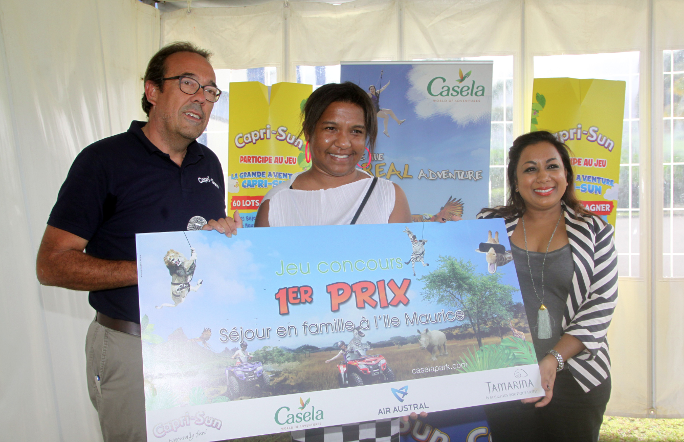 La 1ère grande gagnante du jeu de l'Aventure Capri-Sun, Dora Saidé du Port entouré de Benoît Rimbaud, directeur général de Grand Sud Productions et de Natacha Mudhoo directrice marketing et communication du parc Casela de Maurice